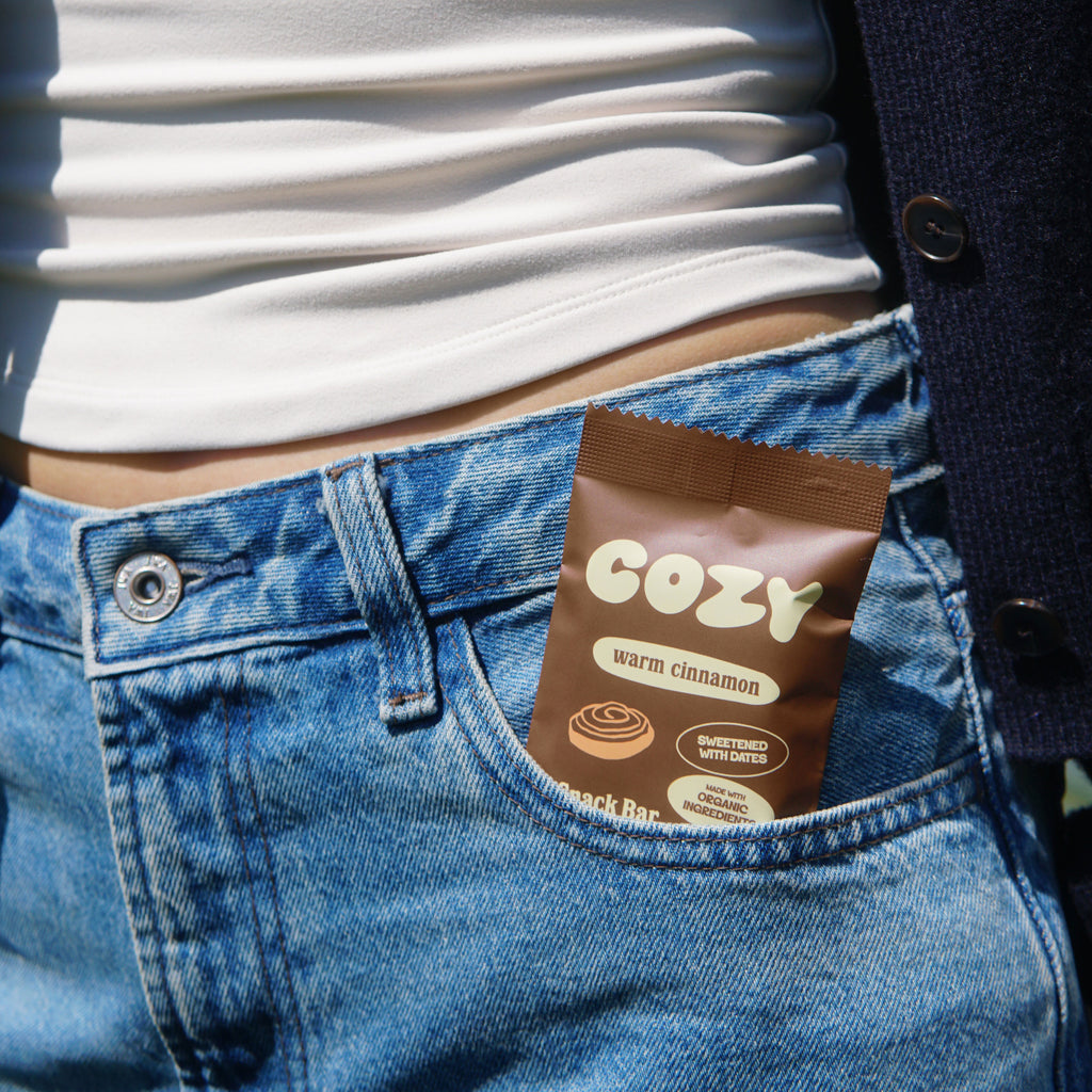 COZY Warm Cinnamon snack bar tucked into a jean pocket, ready to grab and go