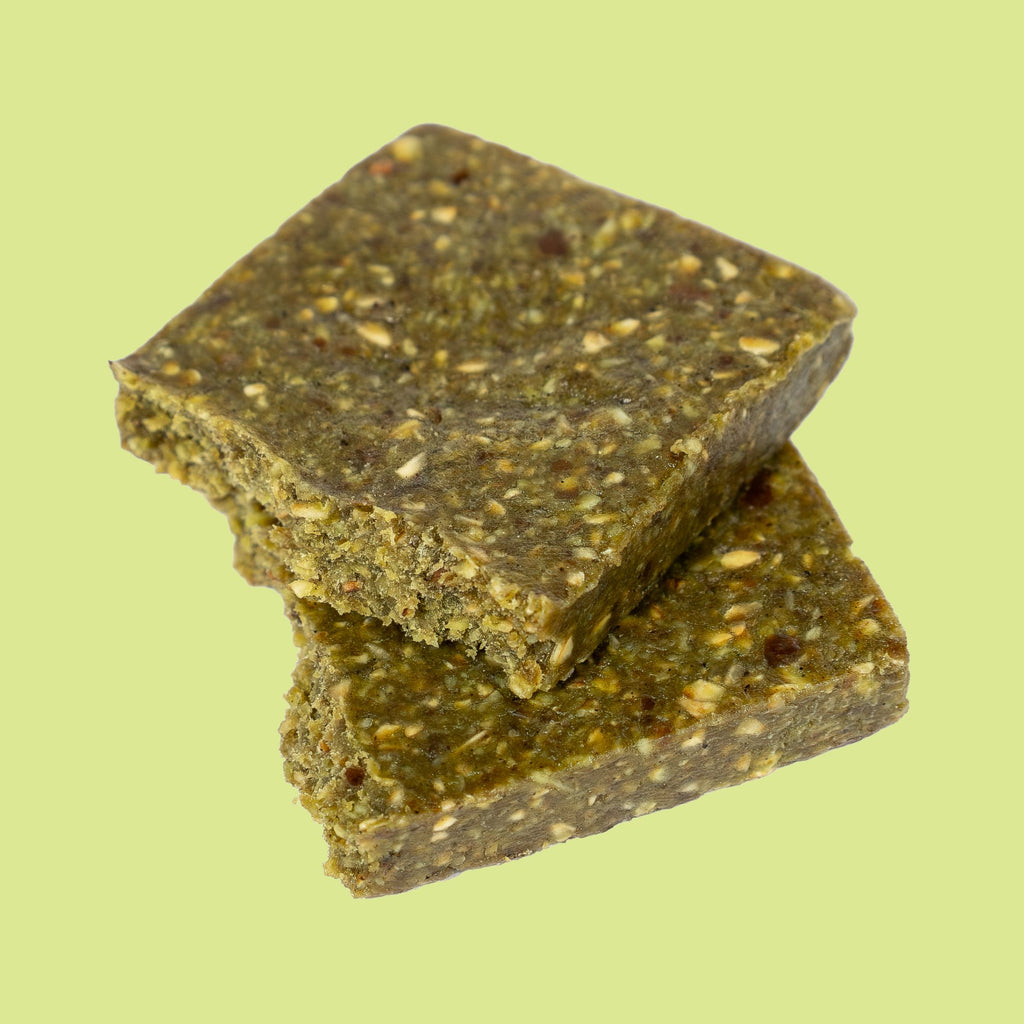 COZY Salted Matcha bar split in half, showing its soft, chewy date and oat texture